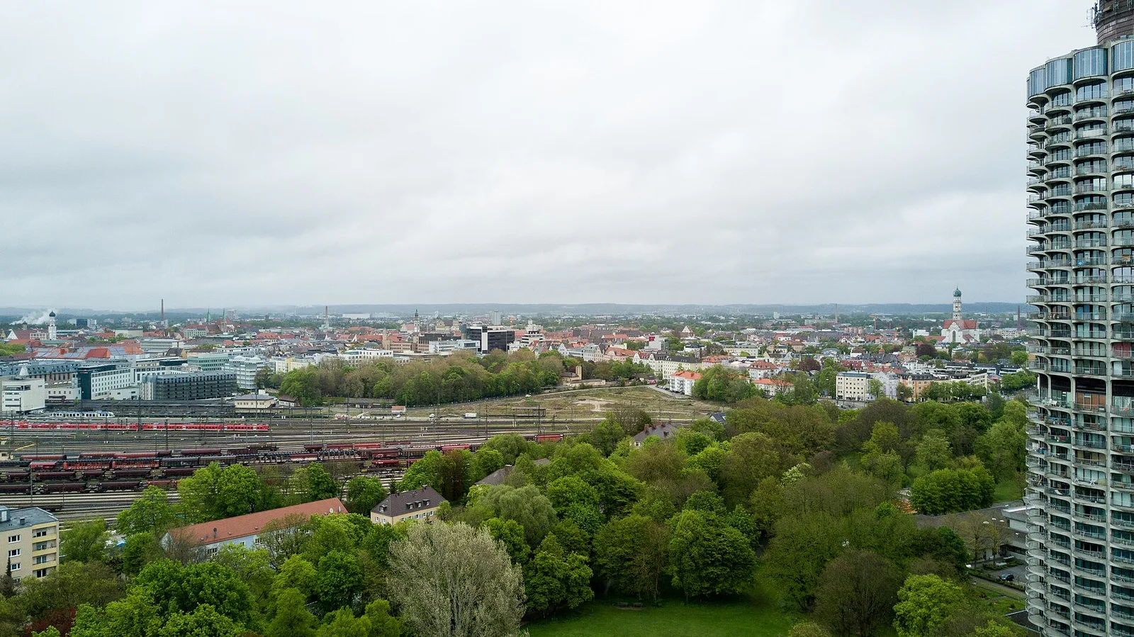 Augsburg skyline, green parkland and Hotelturm photographed in May2017; archival city atmosphere, not the upcoming fixture